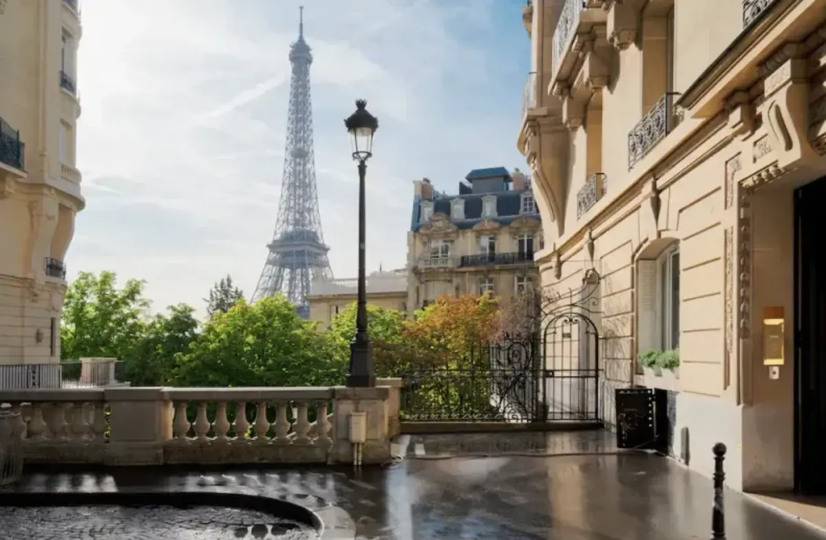 Vue sur la tour Eiffel depuis une rue parisienne avec balustrade