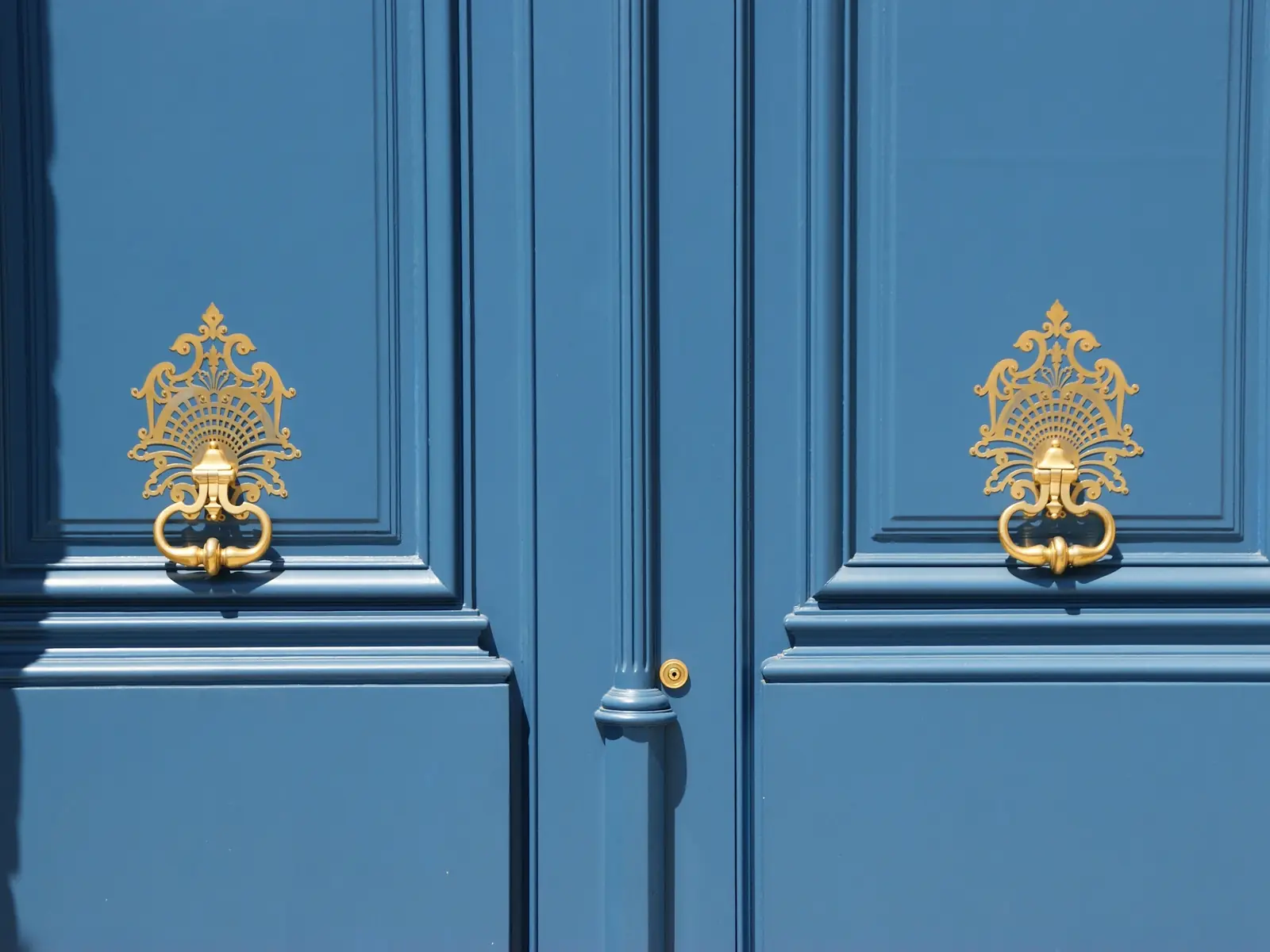 Porte bleue parisienne et ses heurtoirs dorés