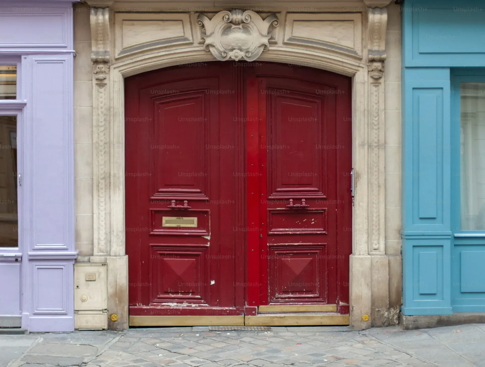 Couple devant deux portes d'appartements parisiens symbolisant le choix entre vendre et acheter